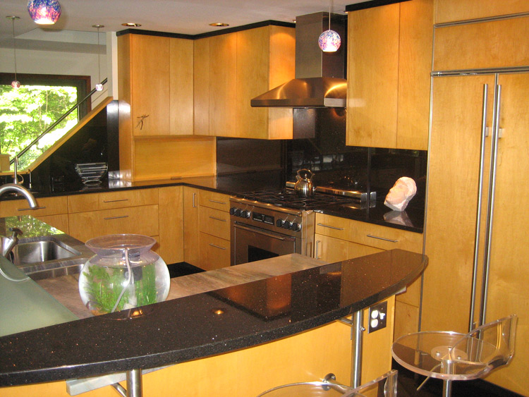 A spacious contemporary kitchen with full overlay natural maple fronts.
